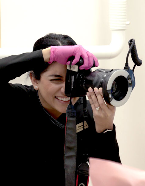 A dentist using a large camera to take a patient's photo at Ironwood Dental Care.
