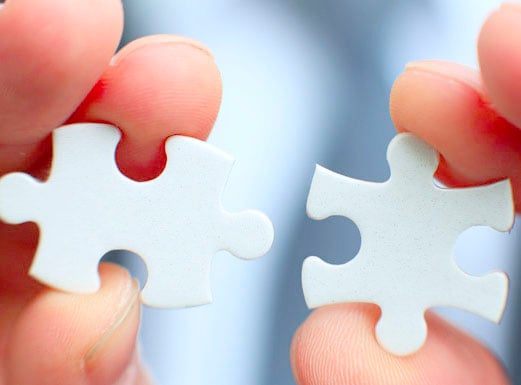 Two jigsaw pieces which fit together.