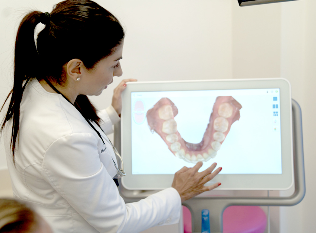 Dr Sheena Sood looking at a scan of a patient's teeth.