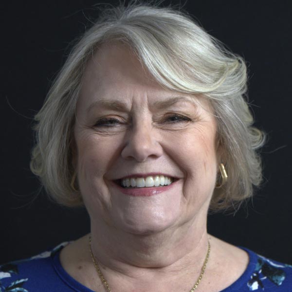 A close-up of an older woman smiling to show her new smile after having dental implants.